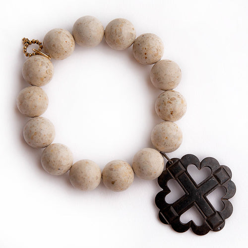 Cream coral paired with a dark bronze heart & cross medal