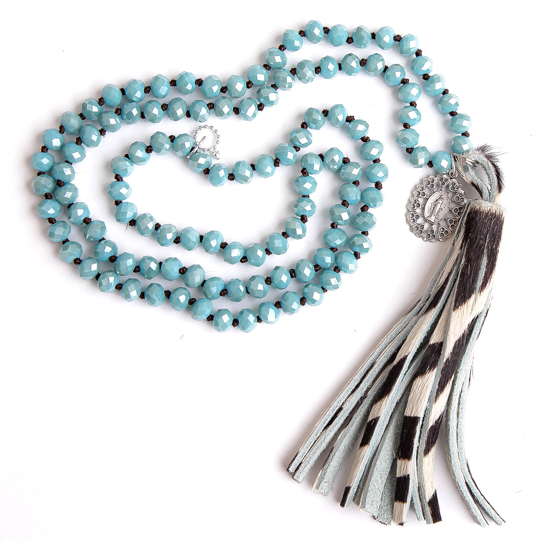 Faceted chambray agate hand tied gemstone necklace paired with a zebra striped leather tassel and silver ornate Blessed Mother medal