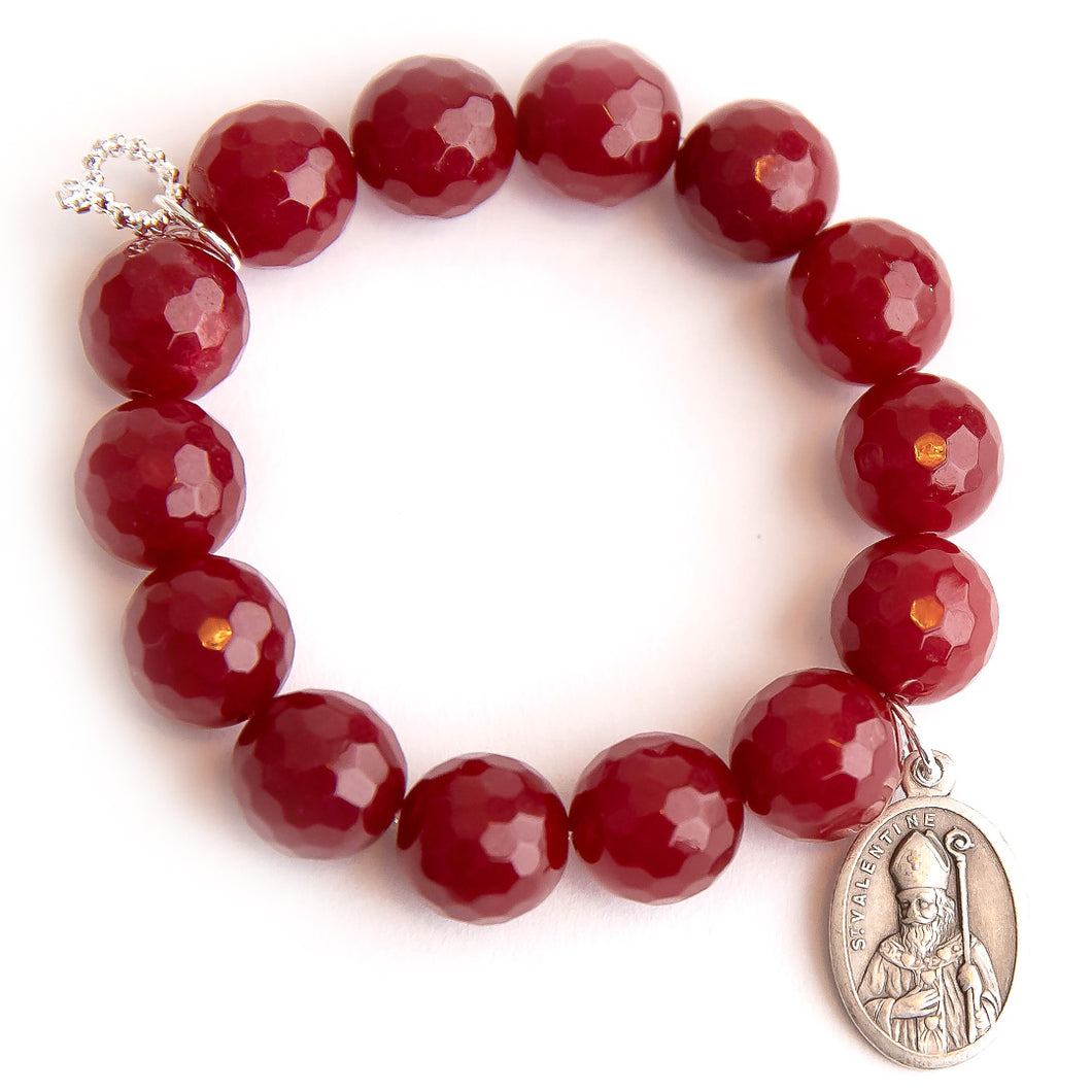 Faceted ruby red jade paired with an oval Saint Valentine medal