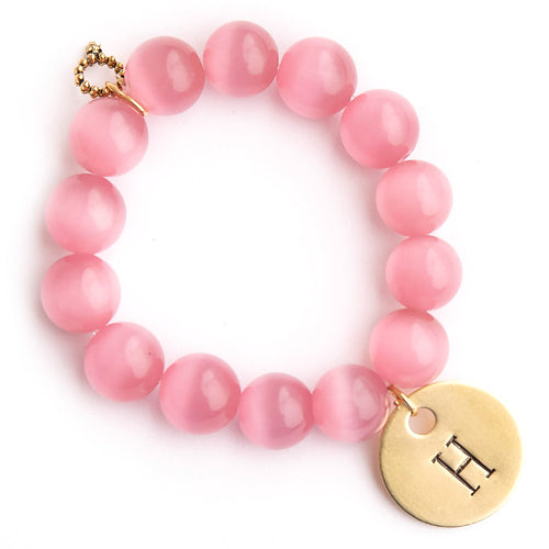 Blush calcite paired with a brass hand stamped initial medal