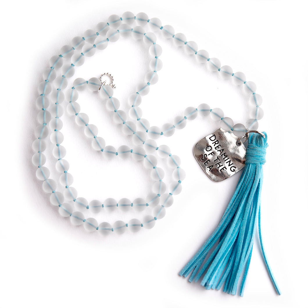 Hand tied frosted quartz gemstone necklace paired with a blue leather tassel featuring a dreaming of the sea medal