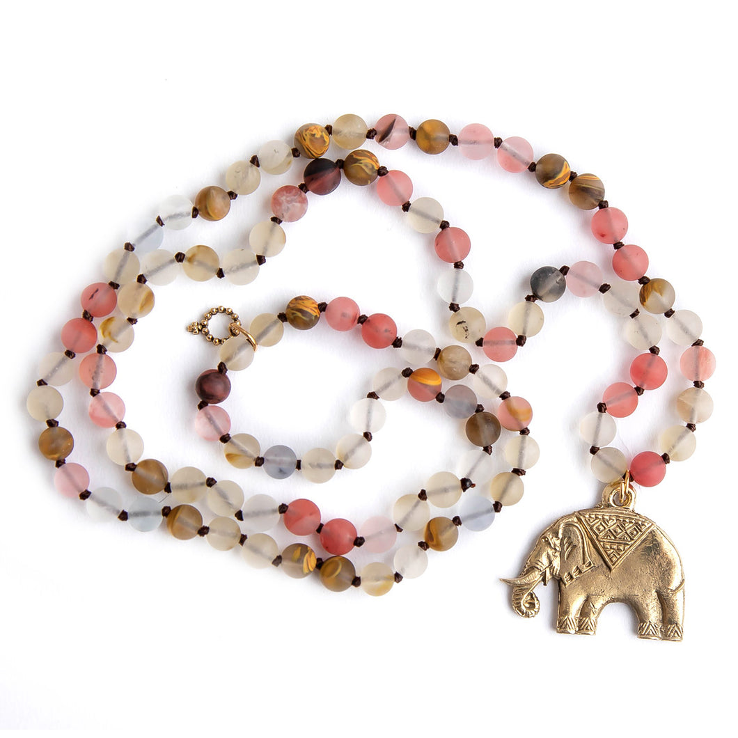 Hand tied matte cherry quartz gemstone necklace paired with a bronze elephant